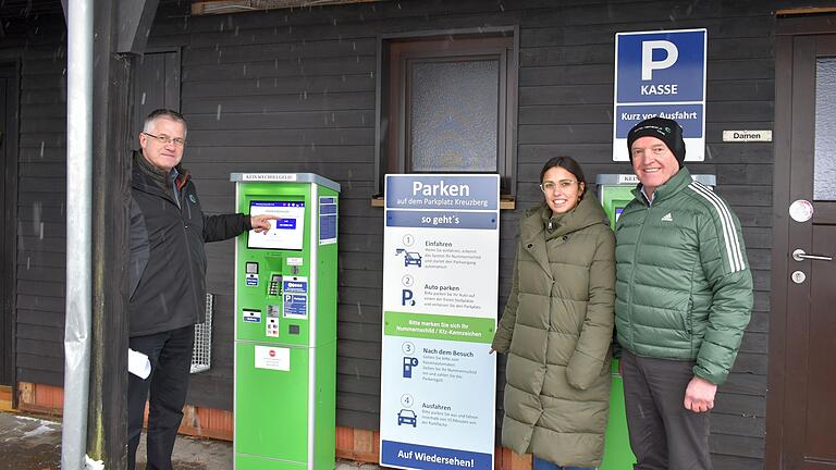 Gerald Roßhirt, Leiter des Kommunalunternehmens Rhön-Grabfeld (KU), KU-Mitarbeiterin Katharina Buhl und Landrat Thomas Habermann stellten bei Schneefall das neue Parksystem am Kloster Kreuzberg vor.