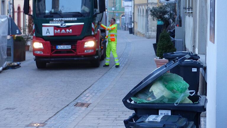 Kurz nach sechs Uhr: Der Müll-Lkw fährt durch die Volkacher Altstadt und sammelt den Müll ein. Manche Tonnen quellen über.