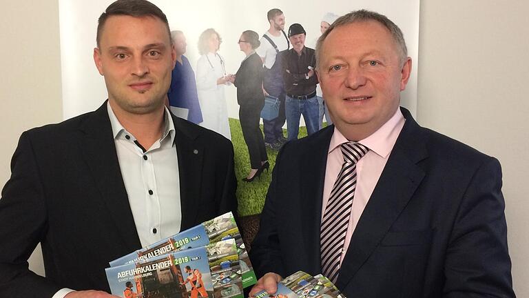 Johannes Gsell (Kommunalunternehmen des Landkreises Bad Kissingen) und Landrat Thomas Bold (von links) präsentieren den neuen Abfuhrkalender. Foto: Lena Pfister       -  Johannes Gsell (Kommunalunternehmen des Landkreises Bad Kissingen) und Landrat Thomas Bold (von links) präsentieren den neuen Abfuhrkalender. Foto: Lena Pfister