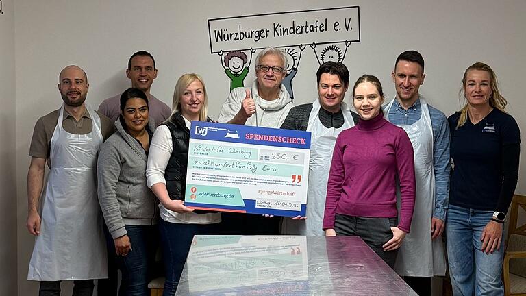 Die Wirtschaftsjunioren Würzburg überreichen eine Spende in Höhe von 250 Euro an Hans Berthold Weigand (5. von links) von der Würzburger Kindertafel.