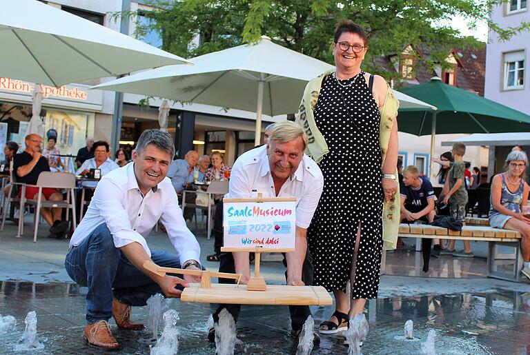 Bürgermeister Michael Kraus, Hanns Friedrich und am-Geschäftsführerin Brigitte Proß ließen das Saale-Musicum-Floß im Brunnen symbolisch zu Wasser.