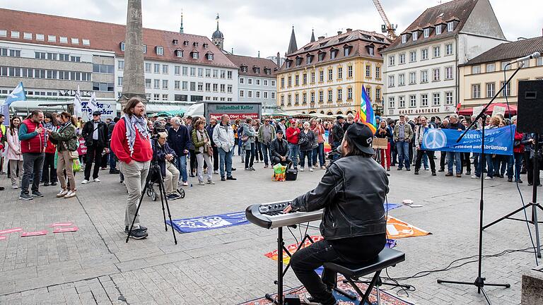 Der Würzburger Musiker Nilz Hübenbecker empfing den Marsch auf dem Marktplatz mit seiner unverkennbaren Musik und untermalte auch die Redebeiträge. Der Würzburger Musiker Nilz Hübenbecker empfing den Marsch auf dem Marktplatz mit seiner unverkennbaren Musik und untermalte auch die Redebeiträge.