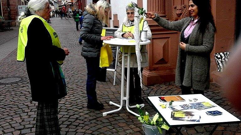 Aktive von amnesty international sammelten in Lohr Unterstützer-Unterschriften. Die Iranerin in der Gruppe hält eine der ausgeteilten gelben Rosen mit einem langen Spitzentuch, weil man das im Iran am Weltfrauentag so macht.