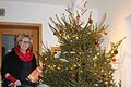 Vorständin Angelika Ochs vor dem festlich geschmückten Christbaum mit den Geschenken für die Kinder.