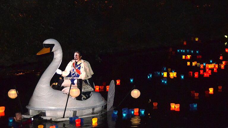 Die Saale als Fluss der Lichter       -  Wenn die Fränkische Saale am Auftaktabend des Rakoczy-Fests zum Fluss der Lichter wird, entfaltet sich für die Besucher eine ganz besondere Atmosphäre. Wenn ausgewählte Figuren aus den Reihen von Bad Kissingens Historischen Persönlichkeiten auf Booten über den Fluss gleiten und König Ludwig II. standesgemäß im Schwanenboot fährt, geht für viele das Bad Kissinger Stadtfest erst richtig los. Seinen Reiz entwickelte das Ereignis &bdquo;Die Saale brennt&ldquo; dieses Jahr wieder näher an der Tradition. Auf die Lasershow der vergangenen Jahre verzichteten die Organisatoren diesmal. (pr)