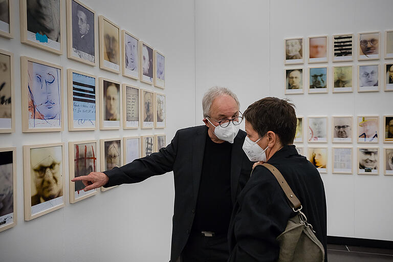 Künstler Jürgen Hochmuth spricht mit einer Besucherin der Triennale über seine Fotografien zum Thema 'Vaterhaus 3.0'