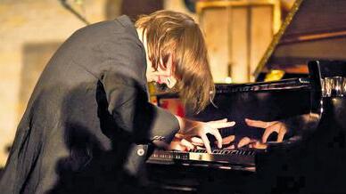 Schwer zu fotografieren: Michael Wollny in typischer Haltung bei einem Konzert im Dezember in der Schweinfurter Christuskirche.