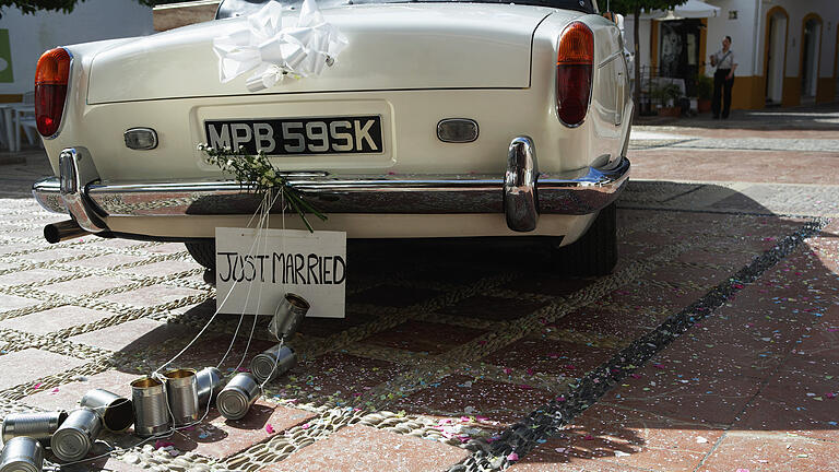 'Just married' sign and tin cans on rear of car       -  Wer sich für ein besonderes Hochzeitsauto entscheidet, möchte mit viel Blumenschmuck und Schleifen auffallen. Dabei sollten allerdings einige Dinge beachtet werden.