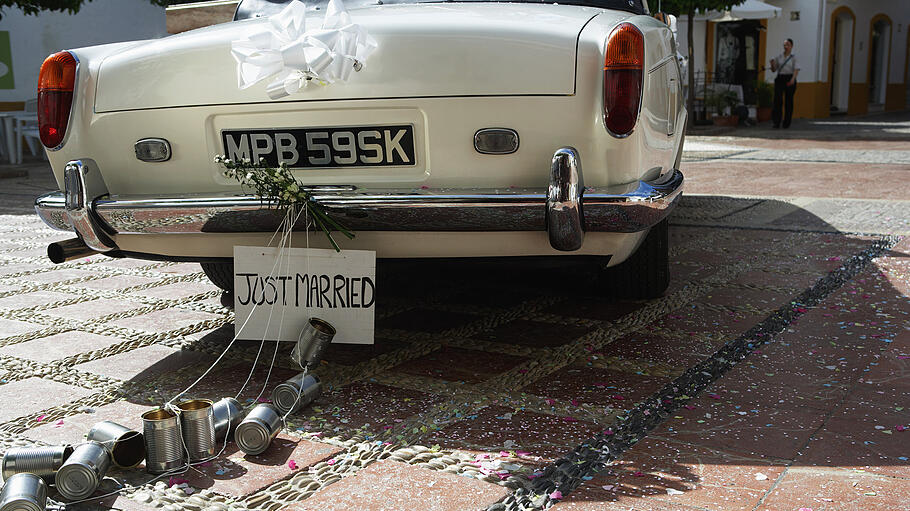 'Just married' sign and tin cans on rear of car       -  Eine Dosen-Banderole für das Hochzeitsauto kann man leicht selbst machen.