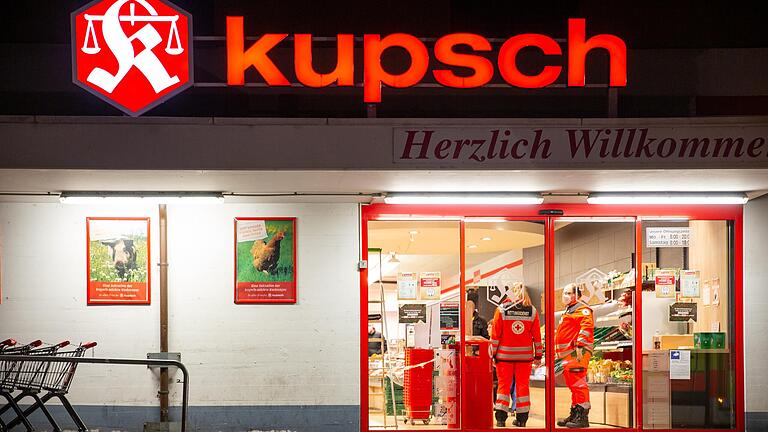 Einsatzkräfte betreuen die Menschen nach dem Überfall in dem Würzburger Kupsch-Markt.