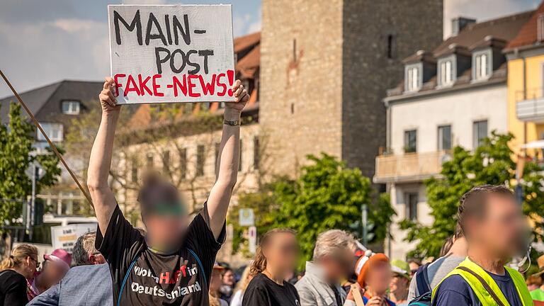 Ein Anhänger der Würzburger 'Querdenker'-Szene (links, mit Schild) stand vor Gericht, weil er einen Richter bedroht haben soll. Auch gegen die Presse hatte er schon demonstriert (Archivbild).