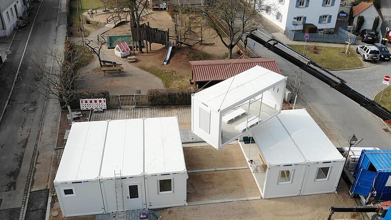Innerhalb weniger Stunden waren die sieben Container-Module auf das Fundament gestellt und verbunden. Hier schwebt gerade der Mittelteil des Gruppenraumes ein (ganz links die Sanitärräume, daneben der Eingangsbereich, der noch ein Vordach erhält, dann Gruppen- und Schlafraum). Innerhalb weniger Stunden waren die sieben Container-Module auf das Fundament gestellt und verbunden. Hier schwebt gerade der Mittelteil des Gruppenraumes ein (ganz links die Sanitärräume, daneben der Eingangsbereich, der noch ein Vordach erhält, dann Gruppen- und Schlafraum). 