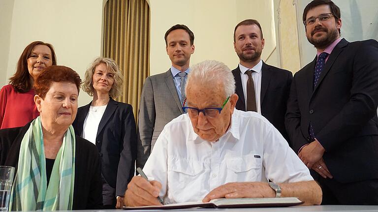 Nach seinem Gespräch mit den Realschülern trug sich Naftali Fürst ins Goldene Buch der Gemeinde Schonungen ein. Unser Bild zeigt (vorne von links) Toba Wagmann-Siegel und Naftali Fürst sowie (hinten von links) Schulleiterin Christine Seuffert, die Organisatorin der Erinnerungsreise, Friederike Bennesch, Landrat Florian Töpper, Bürgermeister Stefan Rottmann und Bernhard Ruckdäschel von der Realschule.