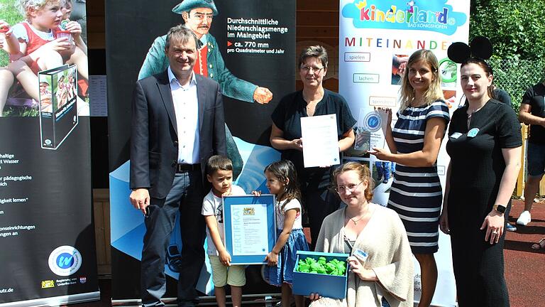 Mit dem Zertifikat, gehalten von Vincent Köth und Asma Alhamada, wird das Kinderland als 'Wasser-Kita' ausgezeichnet im Beisein von (von links) Bürgermeister Thomas Helbling, Angelika Schönstein, Sophia Nitschke, Beauftragte für die Wasser-Kita, Johanna Schenk und Natia Bagakashvili, ebenfalls Beauftragte für die Wasser-Kita. Mit dem Zertifikat, gehalten von Vincent Köth und Asma Alhamada, wird das Kinderland als 'Wasser-Kita' ausgezeichnet im Beisein von (von links) Bürgermeister Thomas Helbling, Angelika Schönstein, Sophia Nitschke, Beauftragte für die Wasser-Kita, Johanna Schenk und Natia Bagakashvili, ebenfalls Beauftragte für die Wasser-Kita.