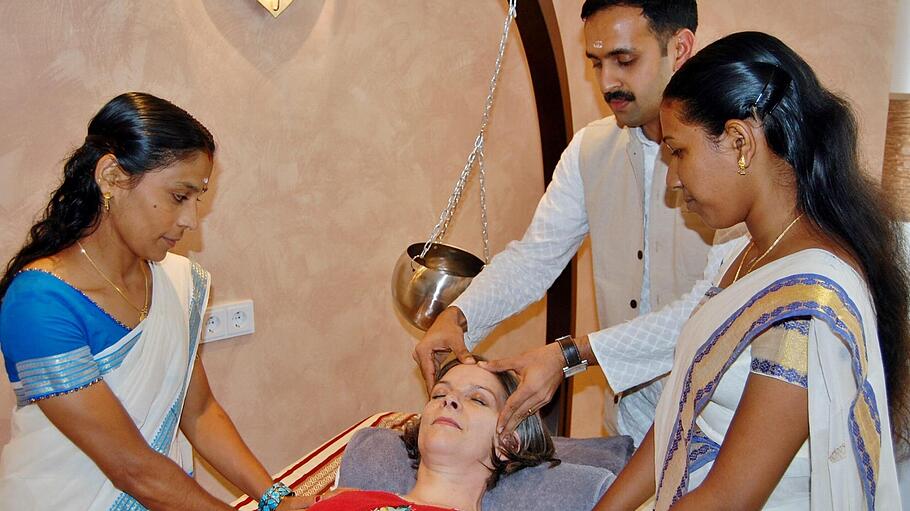 Ayurveda-Arzt Jobin Joy Madukkakuzhy mit seinen indischen Helferinnen bei der Behandlung einer Patientin.  Foto: Sigismund von Dobschütz/Archiv       -  Ayurveda-Arzt Jobin Joy Madukkakuzhy mit seinen indischen Helferinnen bei der Behandlung einer Patientin.  Foto: Sigismund von Dobschütz/Archiv