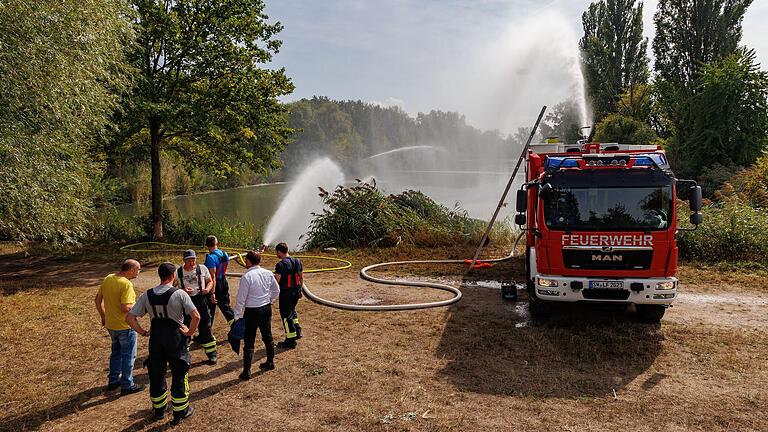 An mehreren Stellen des Sees sind die Feuerwehren im Einsatz und verteilen das abgepumpte, stauerstoffarme Oberflächenwasser mit einem feinen Sprühstrahl.