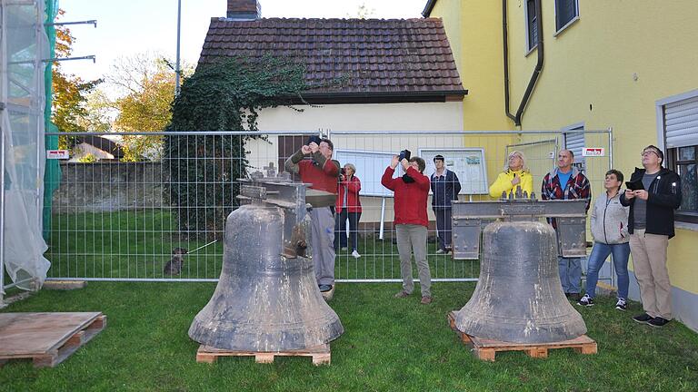 Einige Gernacherinnen und Gernacher verfolgen gespannt, wie die Glocken eine nach der anderen vom Kirchturm geholt werden - und halten diesen historischen Moment mit ihren Smartphones fest.