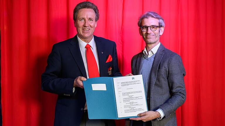 Marco Anderlik (links) und Björn Wilhelm unterzeichneten im Keller des Fastnachtsmuseums in Kitzingen den Vertrag über die Zukunft des fränkischen Fernsehfaschings.