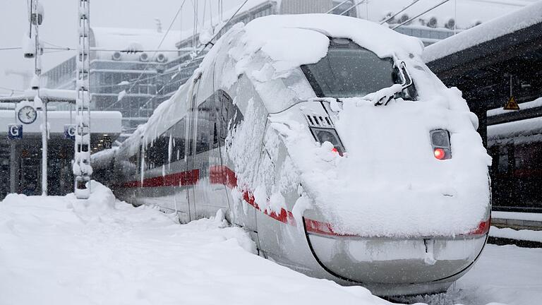 Wintereinbruch in München.jpeg       -  Ein ICE der Deutschen Bahn steht auf einem verschneiten Gleis am Hauptbahnhof in München. Der Wintereinbruch überraschte die Bahn und traf sie mit voller Wucht. Die Lähmung steht sinnbildlich für die vielen Probleme des Staatskonzerns.