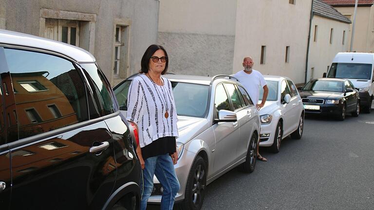 Die Initiatoren des Bürgerantrages Elisabeth Ollmann und Bernhard Fischer vor den parkenden Autos.       -  Die Initiatoren des Bürgerantrages Elisabeth Ollmann und Bernhard Fischer vor den parkenden Autos.