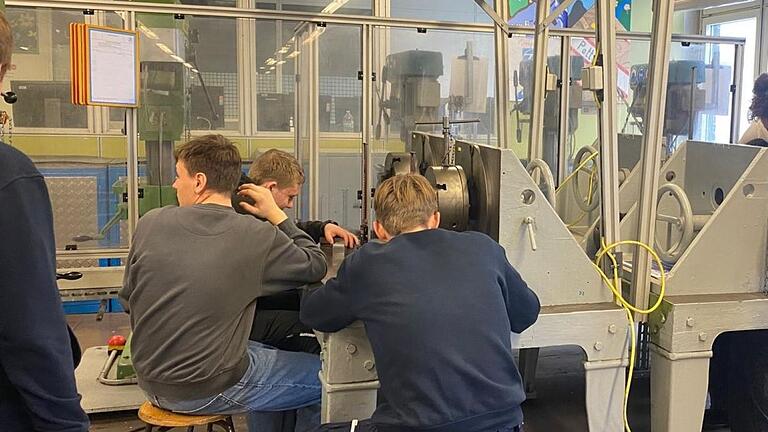 Auszubildende von ZF betreuen die Schülerinnen und Schüler beim Besuch der Ausbildungswerkstatt.