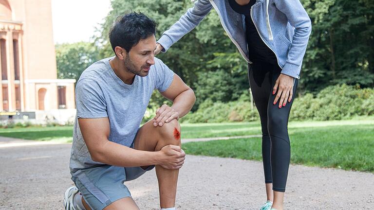 Ein Mann mit einer Schürfwunde am Knie       -  Bei Schürfwunden ist die Infektionsgefahr besonders groß: Nach dem Desinfizieren sollte die Wunde mit einem geeigneten Pflaster abgedeckt werden.