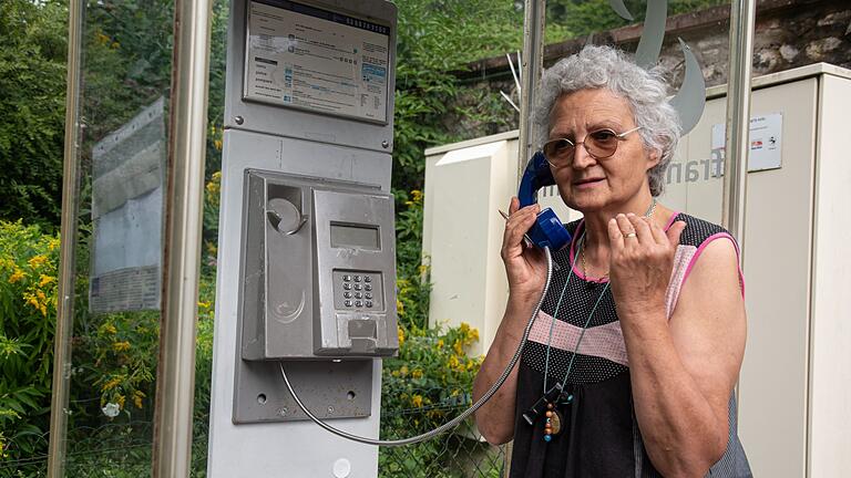 Telefonzelle in Frankreich       -  Marie-Claude König nimmt in Murbach einen Anruf entgegen. In der Telefonzelle im Elsass rufen Menschen aus der ganzen Welt an.