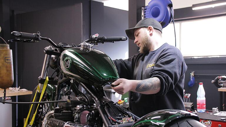 Dieser Umbau geht auf sein Ende zu: Motorradmechaniker Thomas Kolb montiert den Tank auf ein Bobber-Bike.       -  Dieser Umbau geht auf sein Ende zu: Motorradmechaniker Thomas Kolb montiert den Tank auf ein Bobber-Bike.