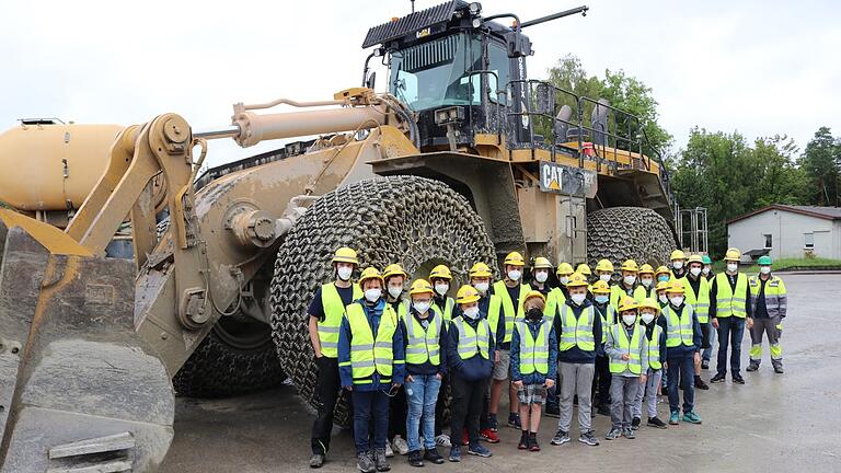 Die Jugendlichen der THW-Jugend Marktheidenfeld mit ihrem Ortsjugendbeauftragten Fabian Fischer (Zweiter von rechts) und Sigmund Oleynik (ganz rechts, grüner Helm) vom Zementwerk Lengfurt, ebenfalls beim THW Marktheidenfeld aktiv, vor den großen Baumaschinen.