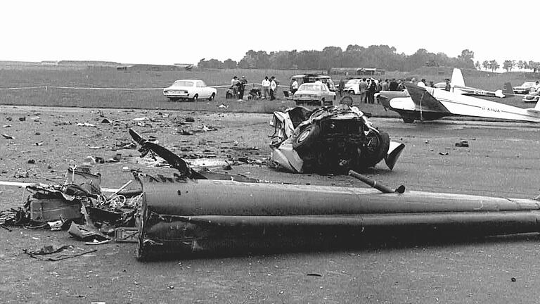 Wrackteile auf der Südseite der Startbahn auf dem Flugplatz Giebelstadt: im Vordergrund das Heck des Helikopters, dahinter der völlig zerstörte Pkw von Augenzeuge Karl-Heinz Krause.