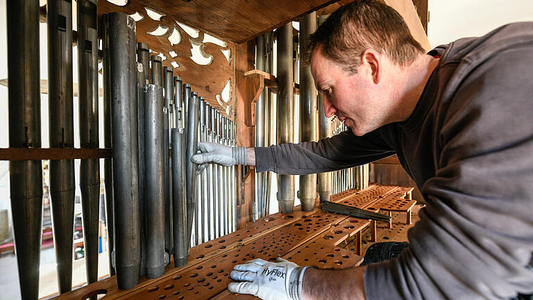Sorgfältig platziert Projektleiter Markus Wolpert nach der monatelangen Sanierung des Instruments die Orgelpfeifen. Viele Originalteile blieben erhalten.