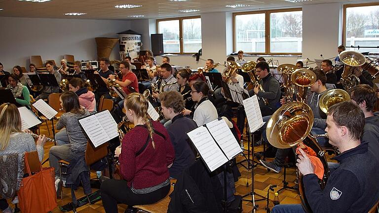 Kreisorchester Haßberge probt für Benefizkonzerte       -  (swe)   Blaskapellen haben Nachwuchsprobleme? Bei der Probe des Kreisorchesters Haßberge des Nordbayerischen Musikbundes mag man es kaum glauben. Auf Mitte 20 schätzt Benedikt Feustel das Durchschnittsalter des Orchesters. 50 Musikerinnen und Musiker scharen sich in diesem Jahr um den Kreisdirigenten, um sich auf die beiden Benefizkonzerte vorzubereiten. Diese finden statt am Samstag, 24. Februar, um 19.30 Uhr im OAZ in Trossenfurt und am Sonntag, 25. Februar, um 17 Uhr im Haus des Gastes in Hofheim. &bdquo;Ihr habt was anderes im Ohr, glaub ich. Die Viertel ist zu früh, die Achtel ein bissel zu spät. Wir sprechen mal die Achtel auf ,Ti'&ldquo;, sagt Benedikt Feustel. Für die Reporterin hatte sich das Stück perfekt angehört, doch jetzt tüftelt der Dirigent an den Feinheiten des Taktes. Alle sind hochkonzentriert dabei, wiederholen noch mal und noch mal, bis es passt. Genau diese akribische Probenarbeit ist es aber, die die jungen Musiker ins Kreisorchester zieht. Sie kommen aus Blaskapellen des gesamten Landkreises. In einem solchen Orchester mitzuspielen, das ist für sie eine besondere Herausforderung und auch Bereicherung als Musiker. Da nimmt man sich auch die Zeit für die zusätzlichen Proben. Mehrere Wochenenden investieren die Teilnehmer in Register- und Orchesterproben und schließlich in die beiden Konzerte. Für jeden Geschmack wird etwas dabei sein, verspricht Feustel. Der Schwerpunkt wird in diesem Jahr auf Musicals wie &bdquo;König der Löwen&ldquo; oder &bdquo;Elisabeth&ldquo; liegen. Wenn das Kreisorchester auftritt, dann fließt der Erlös immer in gemeinnützige Zwecke. Solche haben auch die diesjährigen Gastgeber-Kapellen ausgewählt. Der Hofheimer Spielmannszug will das Rote Kreuz in Hofheim unterstützen, damit die Schulungs- und Selbsthilfegruppen-Räume einen barrierefreien Zugang erhalten können. Und die Blaskapelle Kirchaich investiert ihren Konzert-Erlös in ihren Nachwuchs, der mit Musiker-Tracht eingekleidet werden soll. Karten für die beiden Konzerte gibt es jeweils an der Abendkasse.