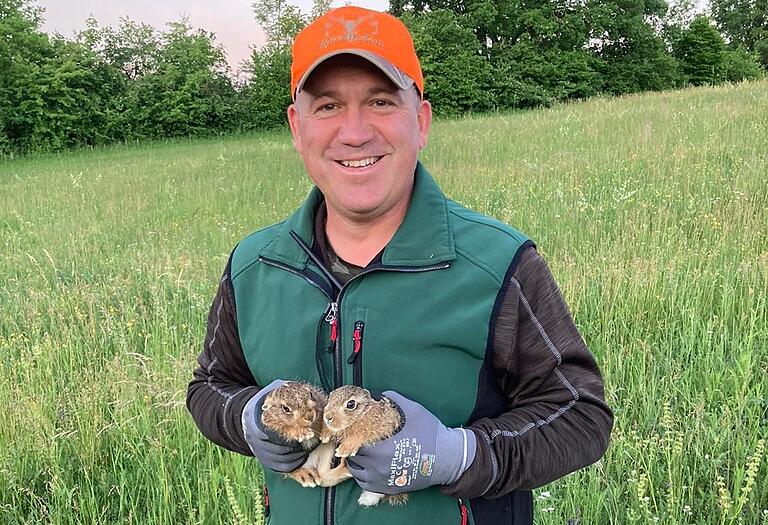 Jäger Matthias Hofmann mit zwei geretteten Hasenjungen in Kitzingen. Jäger Matthias Hofmann mit zwei geretteten Hasenjungen in Kitzingen.
