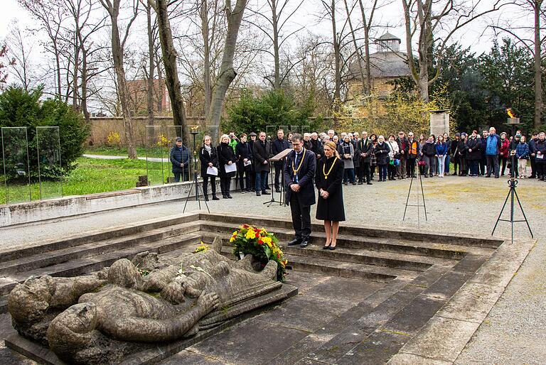 Oberbürgermeister Christian Schuchardt und Bürgermeisterin Judith Roth-Jörg gedenken am Massengrab auf dem Würzburger Hauptfriedhof der Opfer des Bombenangriffs vom 16. März 1945.