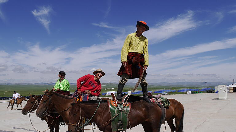 Sattelfest: Mongolische Reiter zeigen bei einem hohen buddhistischen Feiertag nahe Ulan-Bator Kunststückchen.