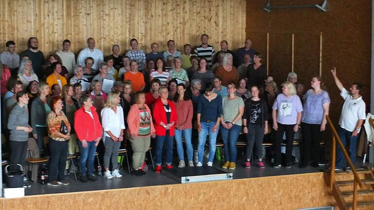 Die Mitglieder des Chorprojekts proben mit Dirigent Oliver Hummel (rechts) für die Konzerte in Gelchsheim und Aub.