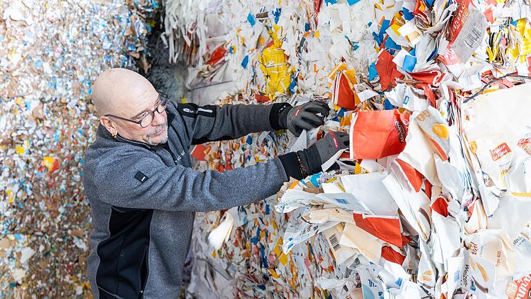 Altpapier und Altkartons sind mit die wichtigsten Rohstoffe bei der Dettelbacher Firma Lindner. Holger Bock wühlt sich hier durch die Stapel im Lager und prüft die Fasern, auf die es später bei der Produktion der Gipsplatten ankommt.