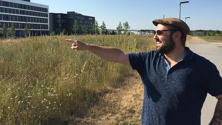 Nachhaltige Universität: Pascal Bunk vom Referat Ökologie der Studierendenvertretung zeigt auf eine &quot;Wuselfläche&quot; - ein Kleinbiotop, das selten gemäht wird.