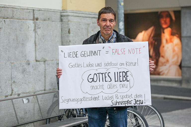Ein Gegendemonstrant stand mit einem selbst gemalten Plakat vor der Kirche. Ein Gegendemonstrant stand mit einem selbst gemalten Plakat vor der Kirche.