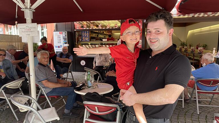 Pedro Martins da Silva und sein Sohn David (im Portugal-Trikot) freuen sich auf das Fußballspiel der deutschen Nationalmannschaft gegen Portugal am Samstag um 18 Uhr. Im Bild steht er vor seinem Eiscafé Cortina am Kitzinger Marktplatz, gerade besucht vom Kitzinger Rentner-Stammtisch. Pedro Martins da Silva und sein Sohn David (im Portugal-Trikot) freuen sich auf das Fußballspiel der deutschen Nationalmannschaft gegen Portugal am Samstag um 18 Uhr. Im Bild steht er vor seinem Eiscafé Cortina am Kitzinger Marktplatz, gerade besucht vom Kitzinger Rentner-Stammtisch.