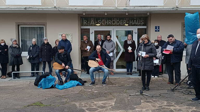 Ein Halbkreis der Anwesenden mit Pfarrerin Wildfeuer am Mikrofon.