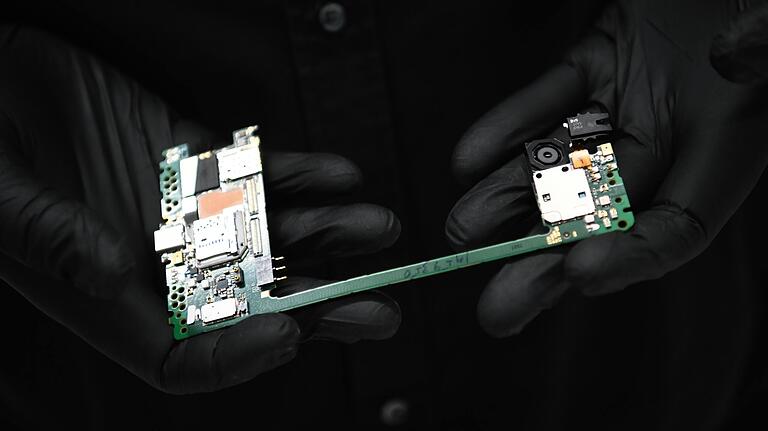 Ein IT-Forensiker zeigt die Hauptplatine eines Smartphones. Ein IT-Forensiker zeigt die Hauptplatine eines Smartphones.