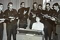 Erika Heim im Jahr 1960 mit dem 'Holy Name Society Choir' im Officers’ Club der Leighton Barracks. Die damals 27-Jährige sitzt an einer Reise-Truhenorgel. 

Foto: Sammlung Erika Heim