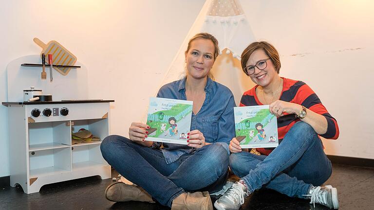 Claudia Görde (Text, im rot-blauen Pulli) und Birgit Six (Illustration) im Café Cosmo in der Würzburger Innenstadt. Die beiden Mütter haben das Kinderbuch „Fritzi und Lulu – Dem Müll auf der Spur“ zum Thema Nachhaltigkeit und Klimaschutz herausgegeben.