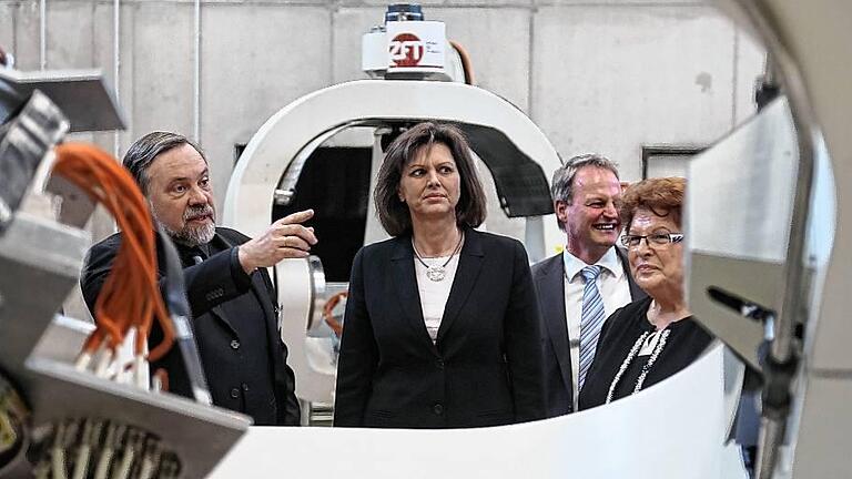 Wirtschaftsministerin Ilse Aigner (Mitte) lässt sich von Klaus Schilling (li./Zentrum für Telematik) im TGZ eine Testvorrichtung für Satelliten erklären. Rechts Landtagspräsidentin Barbara Stamm, hinten TGZ-Geschäftsführer Alexander Zöller.