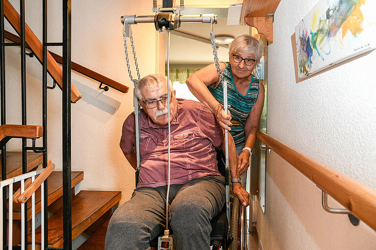 Franziska Heß-Hertlein sichert ihren Mann Ernst samt Rollstuhl im Treppenlift - so gelangt der 74-Jährige über die enge Wendeltreppe in den ersten Stock des Reihenhauses. Franziska Heß-Hertlein sichert ihren Mann Ernst samt Rollstuhl im Treppenlift - so gelangt der 74-Jährige über die enge Wendeltreppe in den ersten Stock des Reihenhauses.