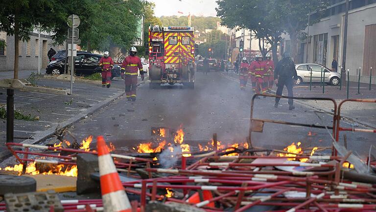 Unruhen in Nanterre.jpeg       -  Feuerwehrleute treffen nach den Ausschreitungen im Pariser Vorort Nanterre ein, um Brände zu löschen.