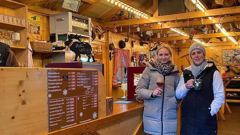 Glühwein kostet auf vielen Weihnachtsmärkten heuer mehr. Auch in Schweinfurt mussten Betreiber und Betreiberinnen wie Curly-Sue Distel (links) an ihrem Glühweinstand 'Elchhütte' die Preise erhöhen.