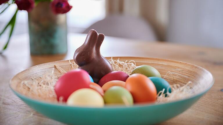 Osterbräuche.jpeg       -  Ein klassisches Osternest beinhaltet bunte Eier und einen Schokohasen.