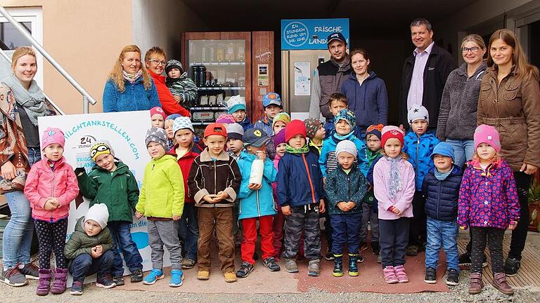 Frische Milch aus dem Zapfhahn in Gädheim       -  In den vergangenen Jahren richteten viele Landwirte eine Milchtankstelle ein. Diese Idee hat Landwirt Florian Schuler übernommen und ist damit der Einzige im Landkreis Haßberge, der Rohmilch an den Endverbraucher, in dieser Art abgeben kann. Darüber hinaus bietet Familie Schuler einige Lebensmittel aus der Region an. Das Angebot im Kühlfach umfasst unter anderem, Eier, Grillfleisch, Bratwurst, Honig, Kartoffeln, Nudeln. Der &bdquo;kleine&ldquo; SB-Laden hat 24 Stunden täglich geöffnet. Am Bauernmarkt, 3. Oktober, wird die Milchtankstelle offiziell eröffnet. Wie einfach das Zapfen der Milch abläuft, bewiesen die Kinder der Kindertagesstätte aus Gädheim mit ihren Betreuerinnen beim Besuch auf dem Bauernhof. Geld einwerfen, Gefäß in den Milchautomaten unter den Zapfhahn stellen und los geht's. Ohne großen Aufwand ist auch der Kauf der Lebensmittel, denn auch dies war für die Kinder wichtig, die viele Fragen an Florian Schuler stellten. Danach wurden die Sprösslinge mit Bananen- bzw. Schokomilch verköstigt. Unser Bild zeigt Florian Schuler (5. von rechts) und Ehefrau Nadja mit den Kindern an der Milchtankstelle.